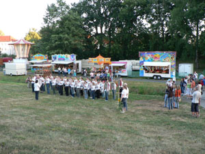 Blaskapelle spielt auf einer Wiese bei einem Fest