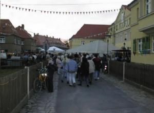 Menschenmenge auf einer Straße mit Festzelten im Hintergrund