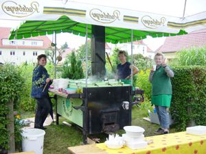 Männer servieren Kohlrabi-Speisen am Grillwagen auf einem Fest