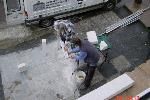 Mann und Kind gießen den Betonfundament für einen Bau