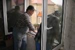 Männer montieren ein weißes Fenster von innen durch die Scheibe