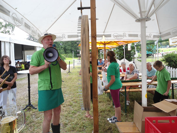 Mann mit Trillerpfeife und Reutrocken unter dem Zelt