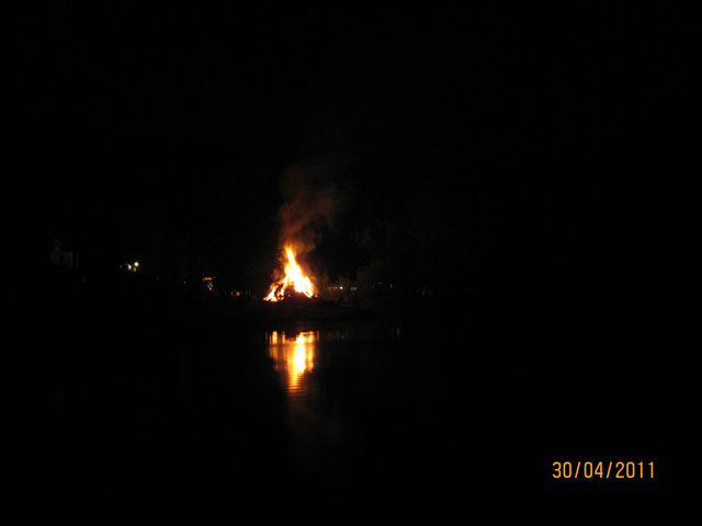 Nachtbrennen mit reflektierender Flamme auf dem Wasser