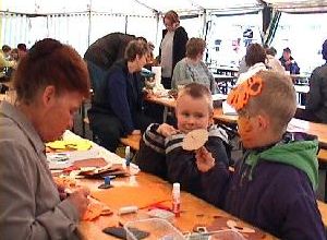 Kinder malen und basteln an einem Basteltisch unter freiem Himmel