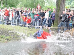 Mann springt im Kostüm ins Wasser vor Zuschauern