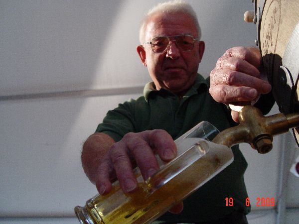 Älterer Mann gießt helles Bier von einem Fass in ein Glas