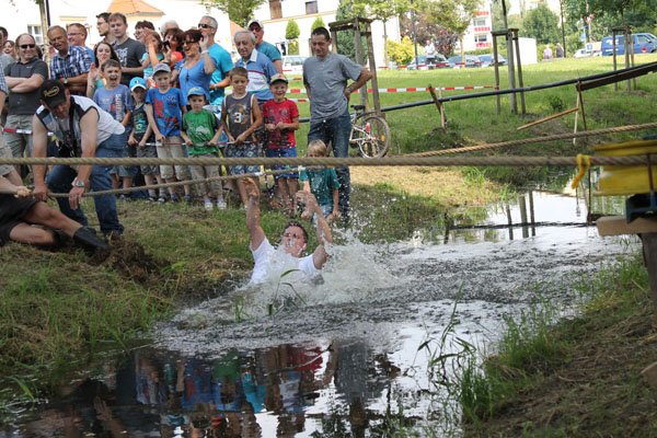 Teilnehmer springt jubelnd in den Wasserteich