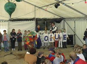Kindergruppe hält Buchstabentafeln während einer Darbietung im Festzelt