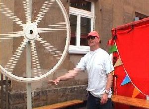 Mann mit rotierendem Weißwasser-Fahrrad vor Festzelt