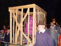 Nächtliche Parade mit großem hölzernen Karren und Figuren