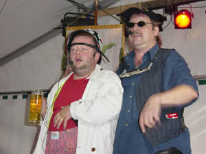 Zwei Männer im Festzelt, einer trägt einen Kronenkranz und hält ein Bier